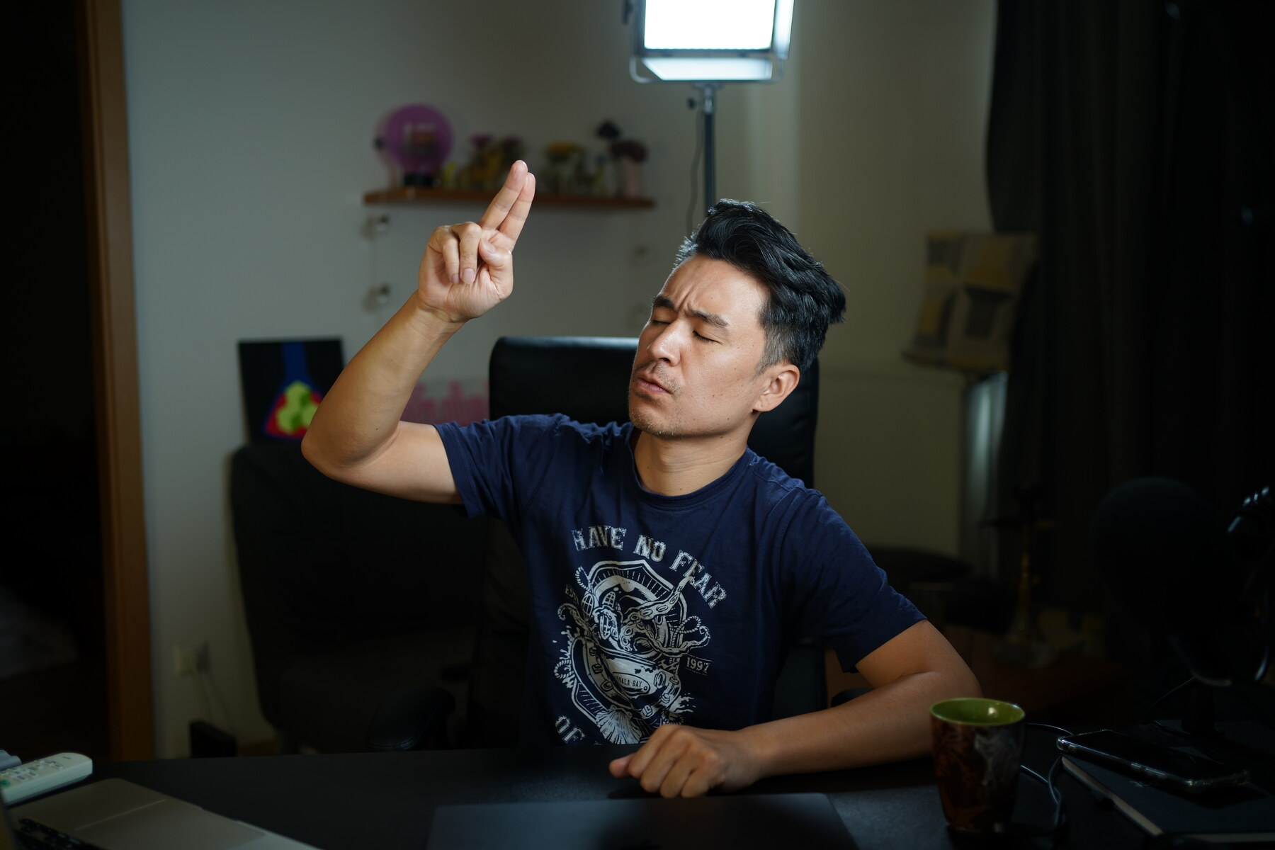 二本指を上げて静かに目を閉じるナオミさんの提供写真