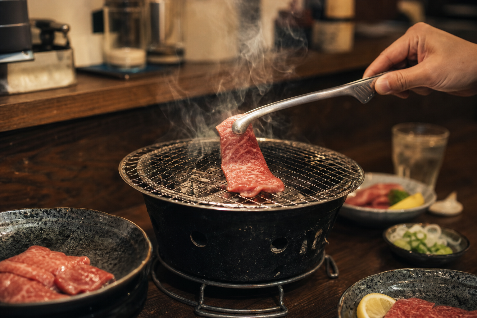 焼肉の網に肉を置く手元